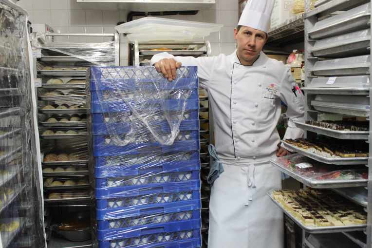 Fort Garry Hotel pastry chef Richard Warren stands in the walk-in cooler amongst racks of cookies, slices, cakes and bread. (Robin Summerfield)